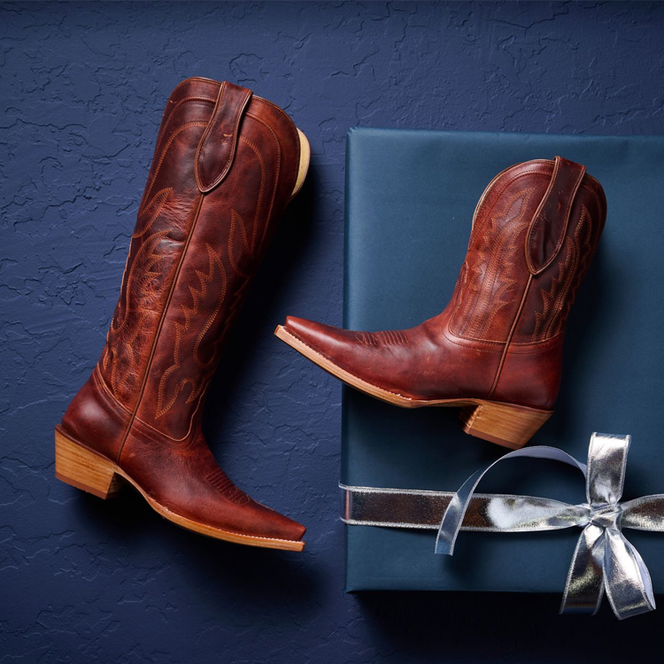 One Jess 15” Women's Western in Cognac and one Areli Women’s Western in Cognac laying on a gift box.